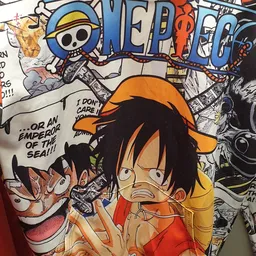 Close-up van een One Piece manga/anime merchandise item met oranje en zwarte kleuren