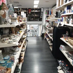 Winkelinterieur met schappen vol huishoudelijke artikelen, decoraties en diversen.