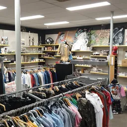 Winkelvloer met kledingrekken, stellingen met diverse artikelen en decoratieve elementen aan de wand