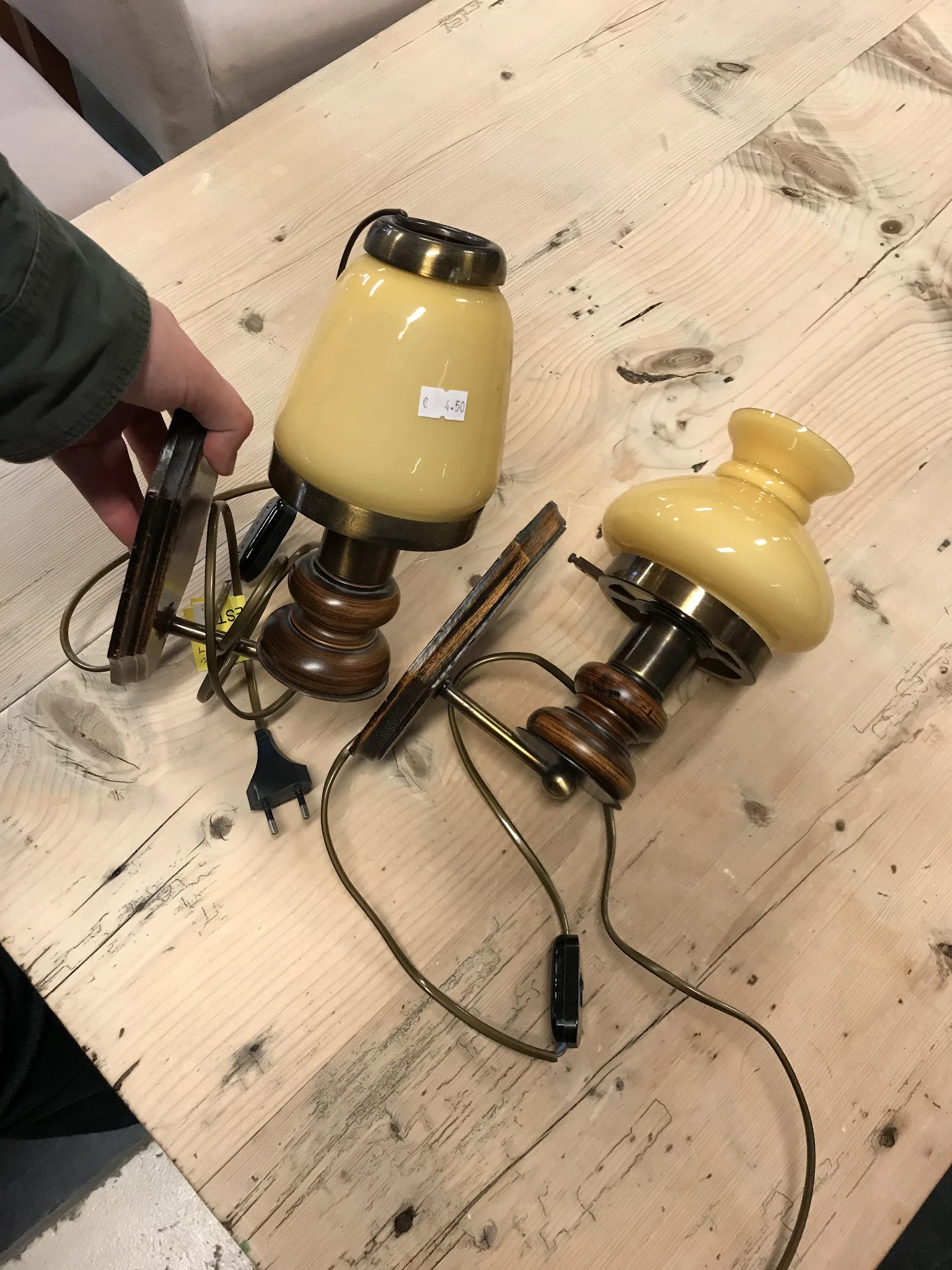 Drie vintage tafellampjes met gele glazen kappen en houten voeten op houten vloer