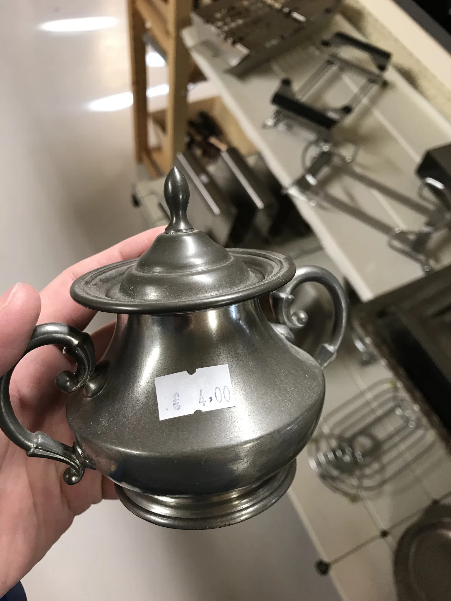 Zilveren tinnen suikerpot met deksel en oren, close-up in hand