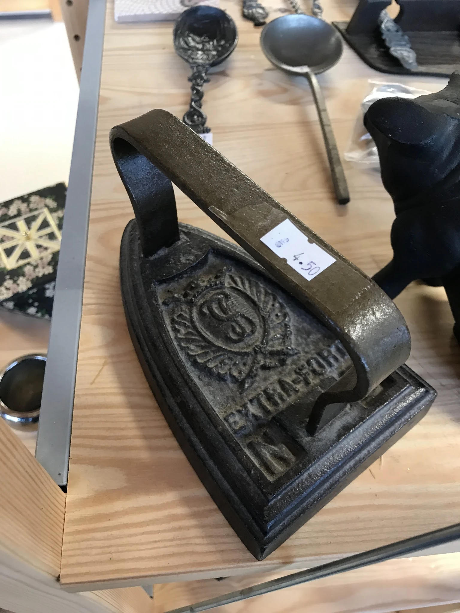 Close-up van een antieke gietijzeren steenklopper met ornamentaal motief en handvat