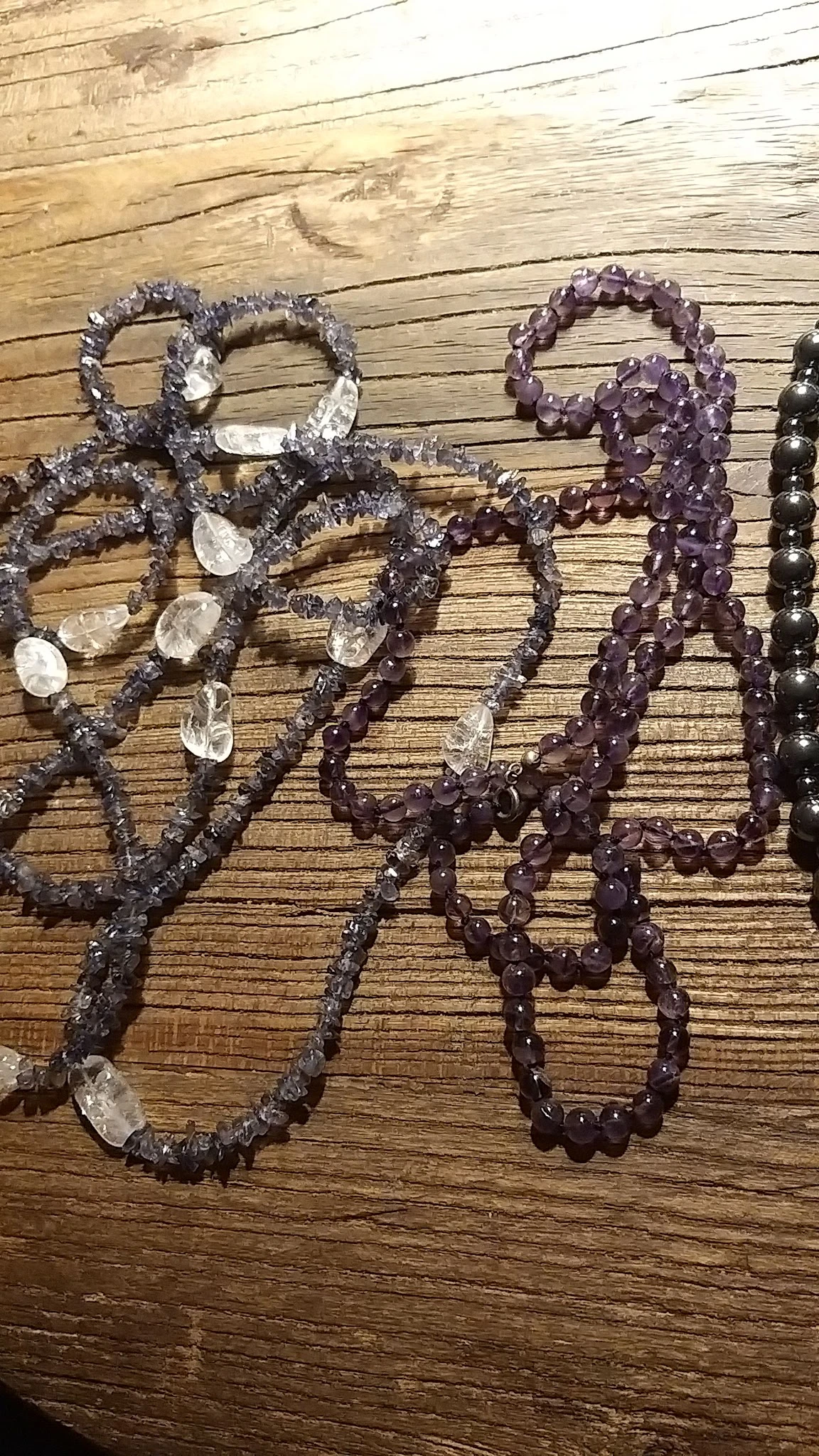Verschillende gekleurde kralen armbanden uitgestald op houten ondergrond