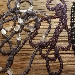 Verschillende gekleurde kralen armbanden uitgestald op houten ondergrond