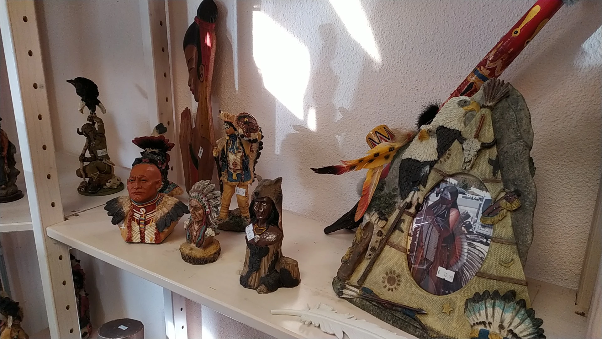 Kasten met decoratieve beelden, maskers en etnische kunstvoorwerpen uitgestald in het zonlicht