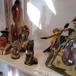 Kasten met decoratieve beelden, maskers en etnische kunstvoorwerpen uitgestald in het zonlicht