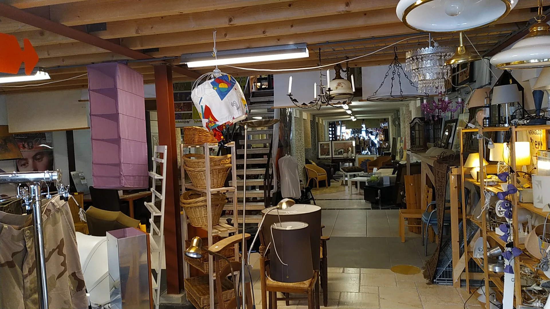 Winkelvloer van kringloopwinkel met stellingen, meubels, lampen en diverse spullen
