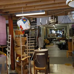 Winkelvloer van kringloopwinkel met stellingen, meubels, lampen en diverse spullen