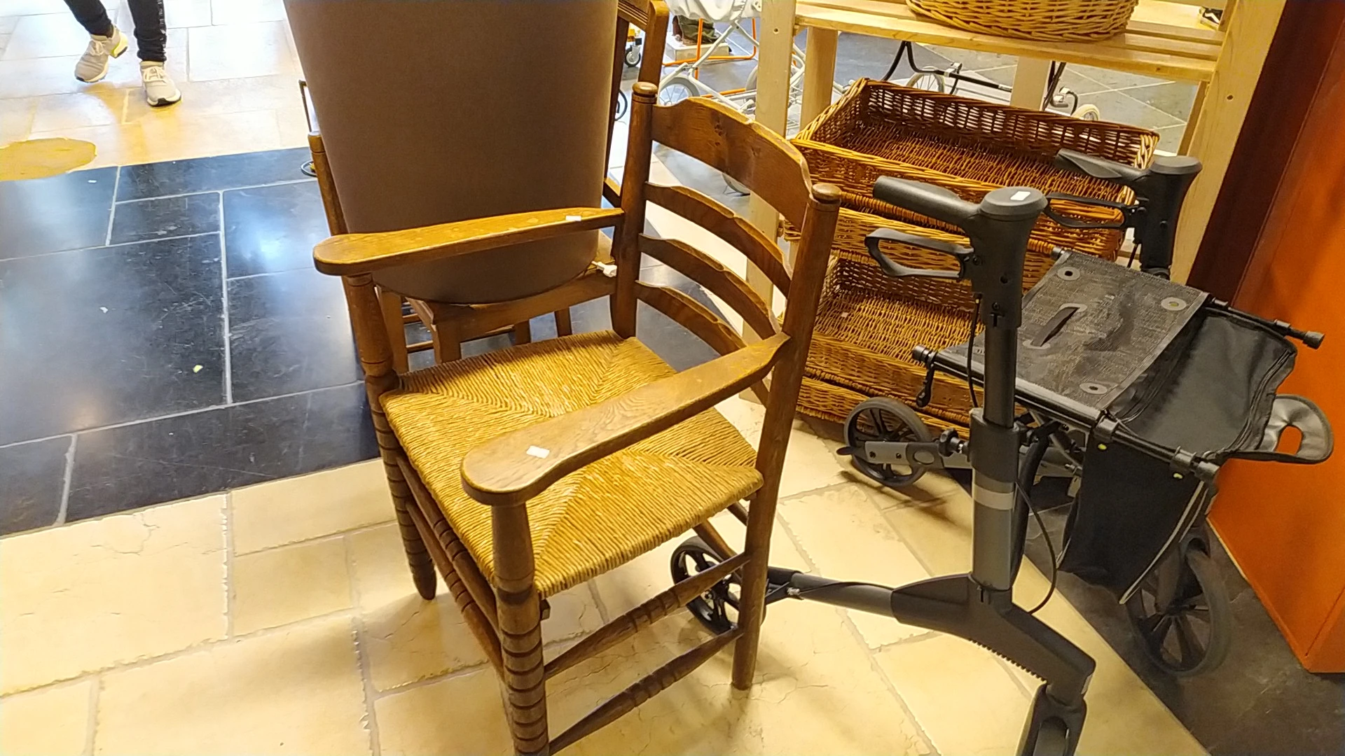 Houten stoel met rieten zitting en bruine rugleuning, geëxposeerd in de winkel