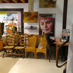 Winkelinterieur met uitgestalde meubels, stoelen en decoratie tegen muren met posters en afbeeldingen