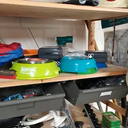 Stellingkast met diverse huishoudartikelen: gekleurde manden, pannen, containers en keukengerei