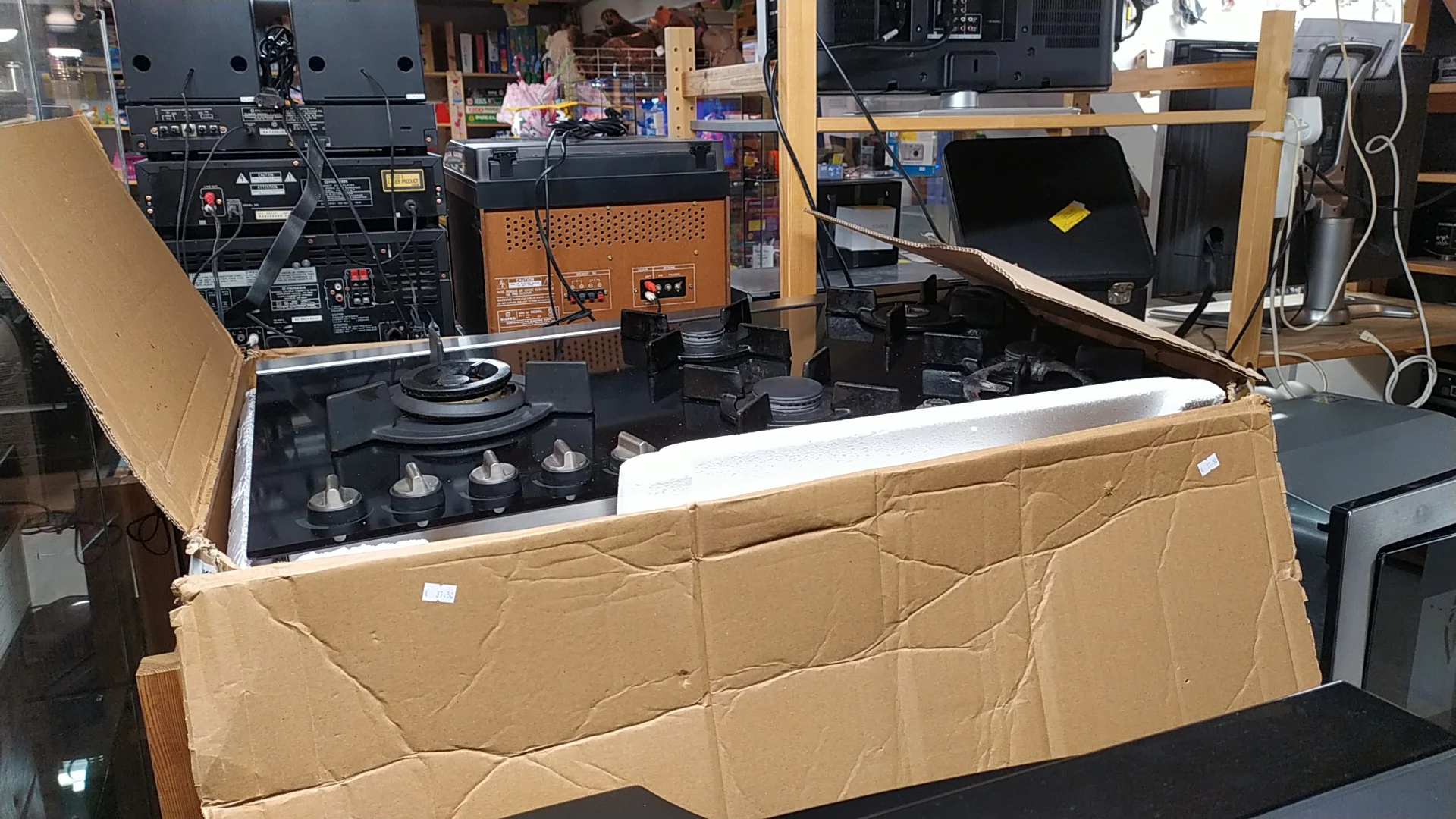 Verschillende huishoudelijke apparaten en elektronica in kartonnen dozen in de winkel