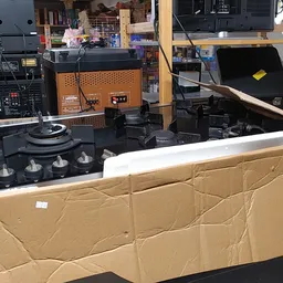 Verschillende huishoudelijke apparaten en elektronica in kartonnen dozen in de winkel