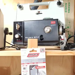 Vintage filmprojectoren en accessoires op een houten werkbank in de winkel