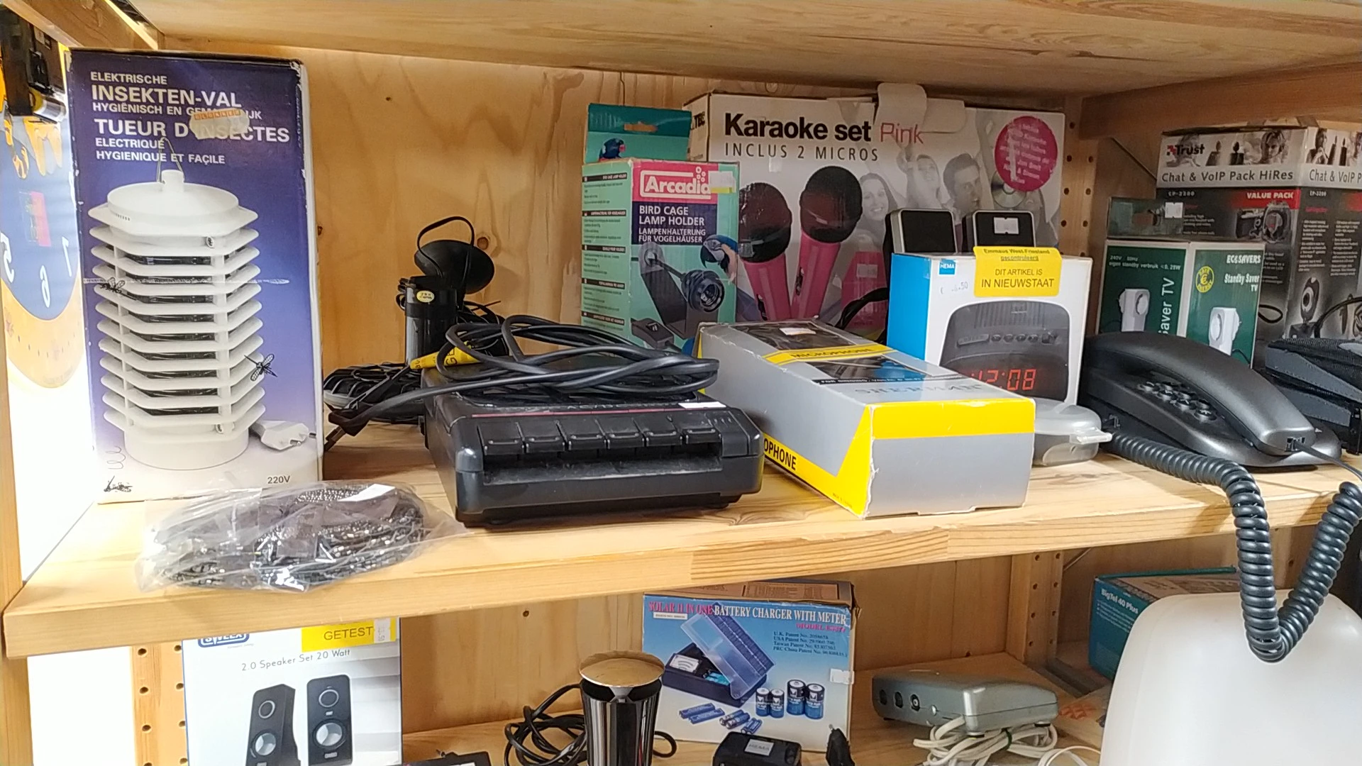 Stellingkast met elektronische apparaten en accessoires zoals karaoke-sets, speakers, apparatuur en verpakte goederen