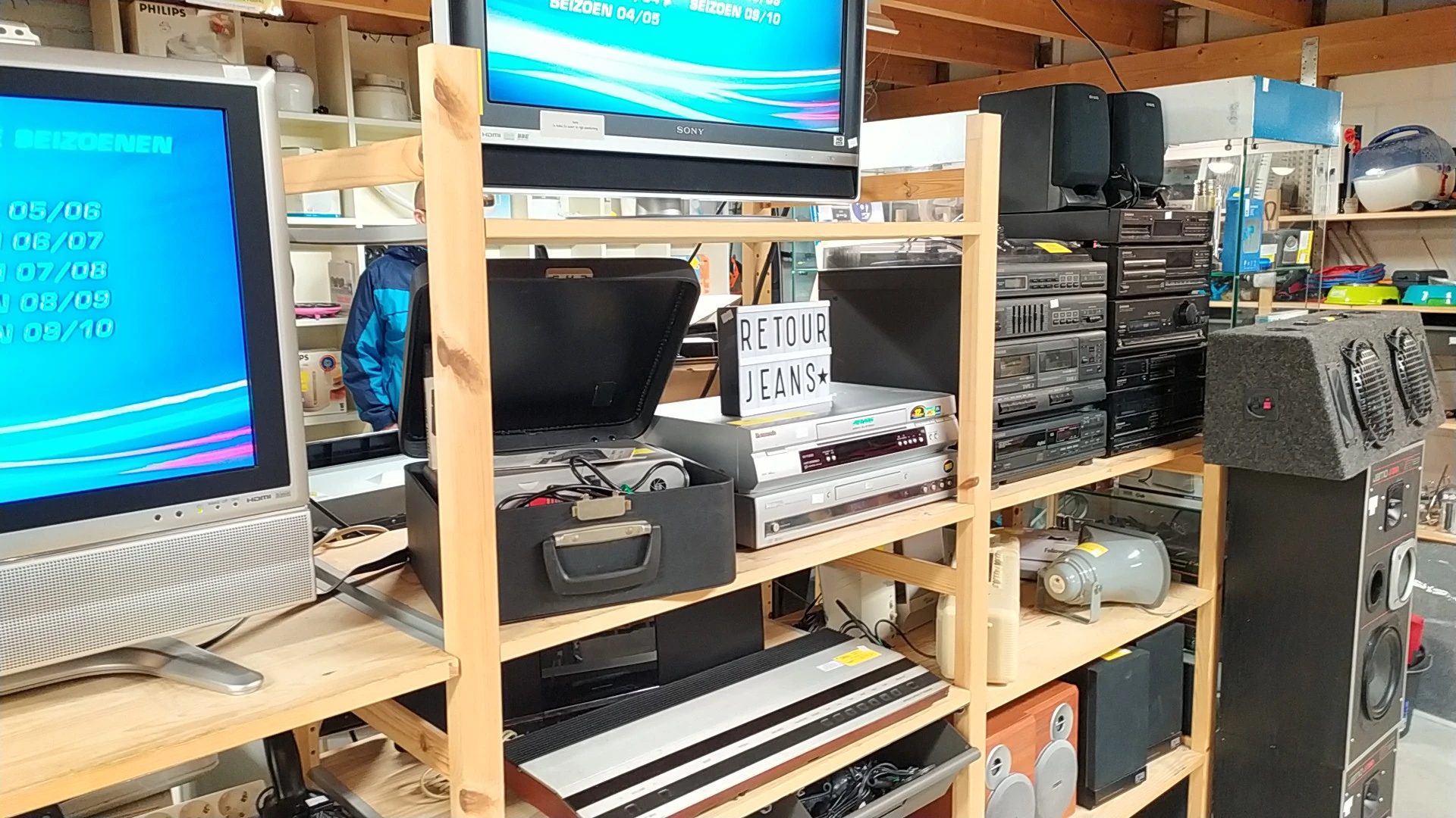 Houten stellingkast met elektronische apparatuur zoals monitors, keyboards, speakers en andere computer- en audiouitrusting u
