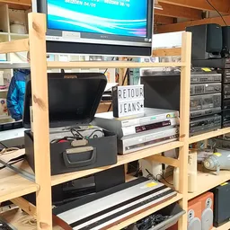 Houten stellingkast met elektronische apparatuur zoals monitors, keyboards, speakers en andere computer- en audiouitrusting u