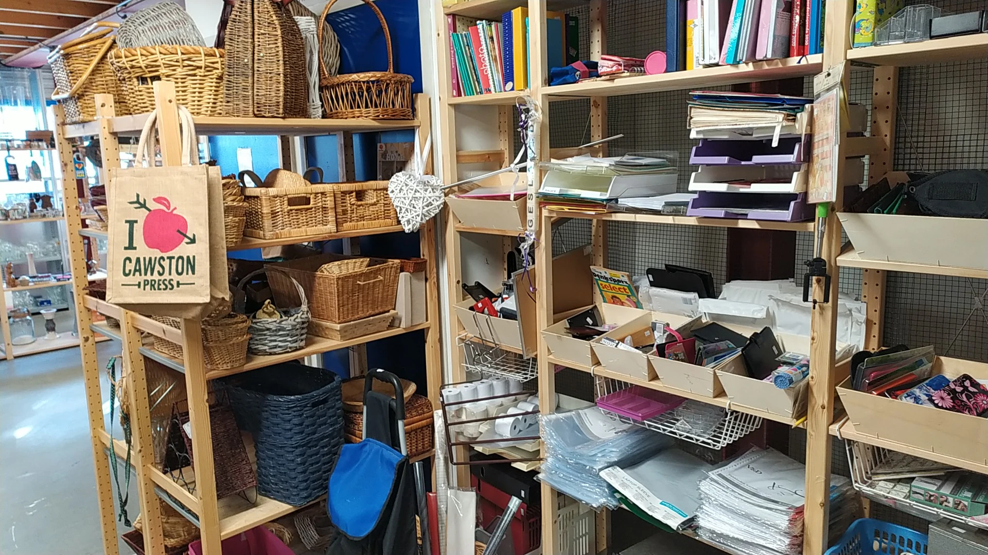 Houten stellingen met opbergmanden, dozen en boeken in een kringloopwinkel