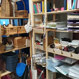 Houten stellingen met opbergmanden, dozen en boeken in een kringloopwinkel