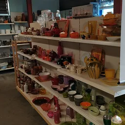 Stellingen met uitgestalde kaarsen, theelichtjes en huishoudartikelen in verschillende kleuren en maten