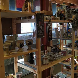 Houten stellingen volgestapeld met diverse tweedehands spullen, beeldjes, decoratie en huishoudartikelen