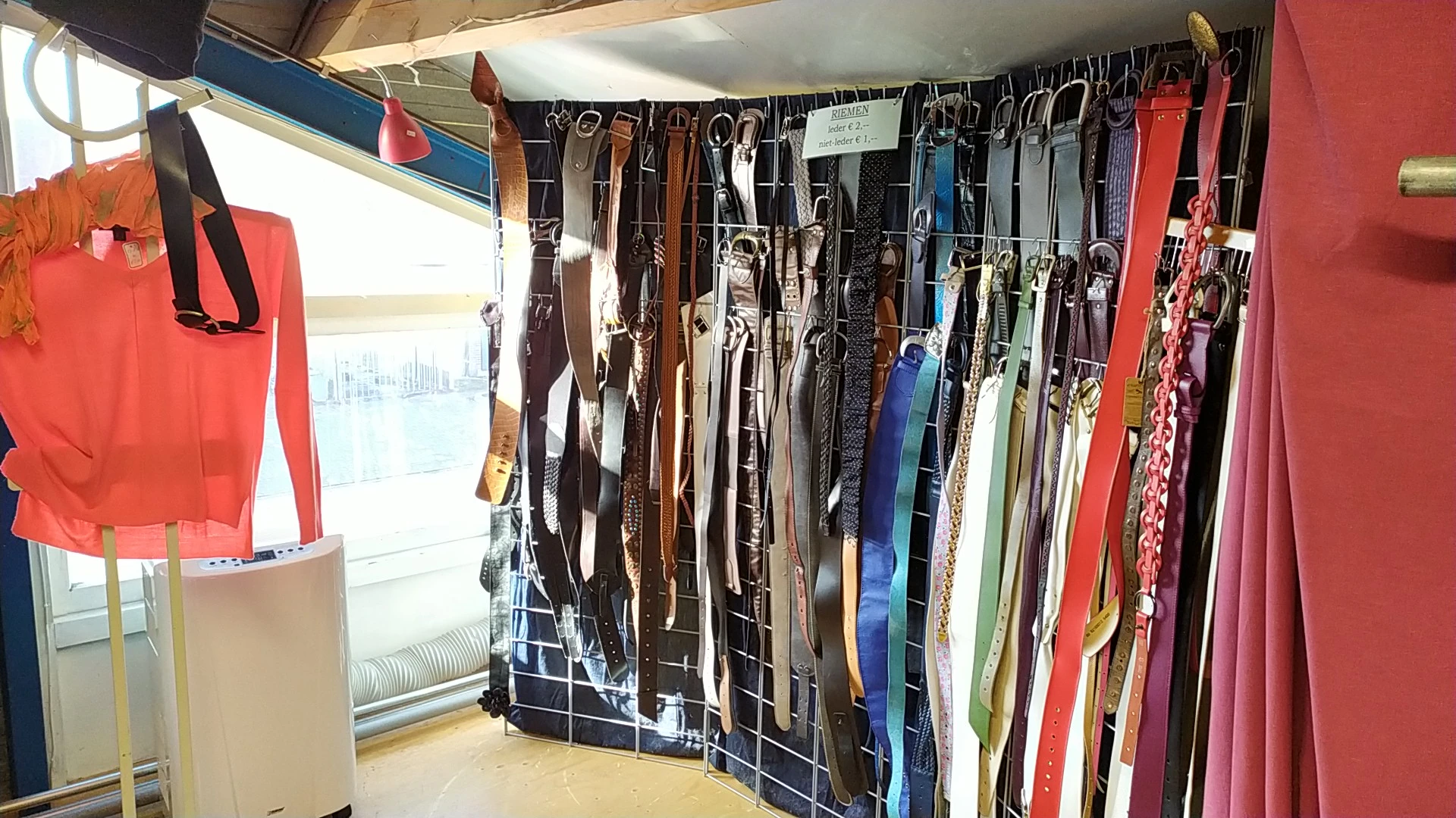 Rekken met diverse tweedehands riemen in verschillende kleuren en stijlen