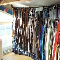 Rekken met diverse tweedehands riemen in verschillende kleuren en stijlen