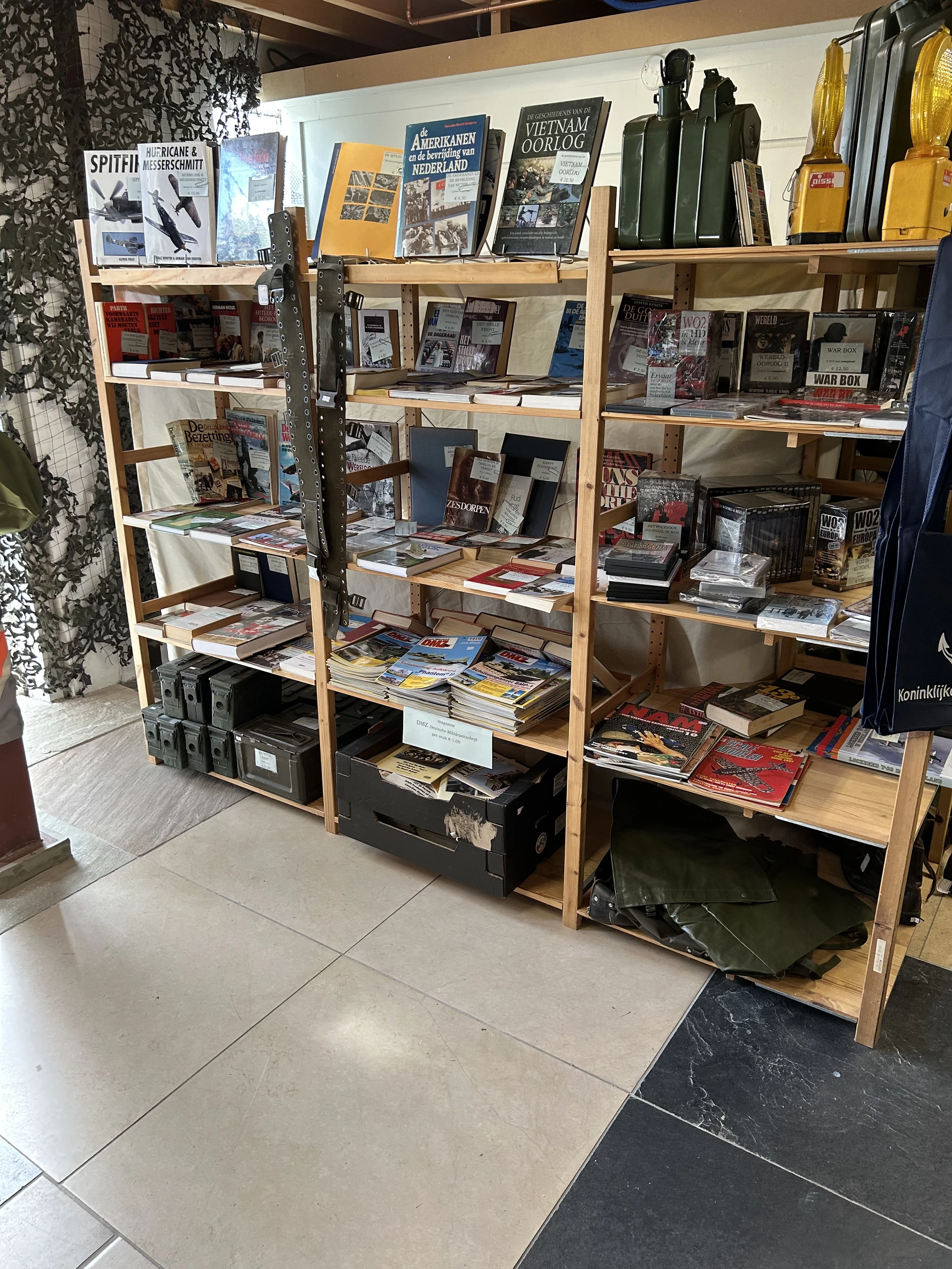 Houten stellingen met tweedehands boeken, dvd's, cd's en media uitgestald op meerdere niveaus