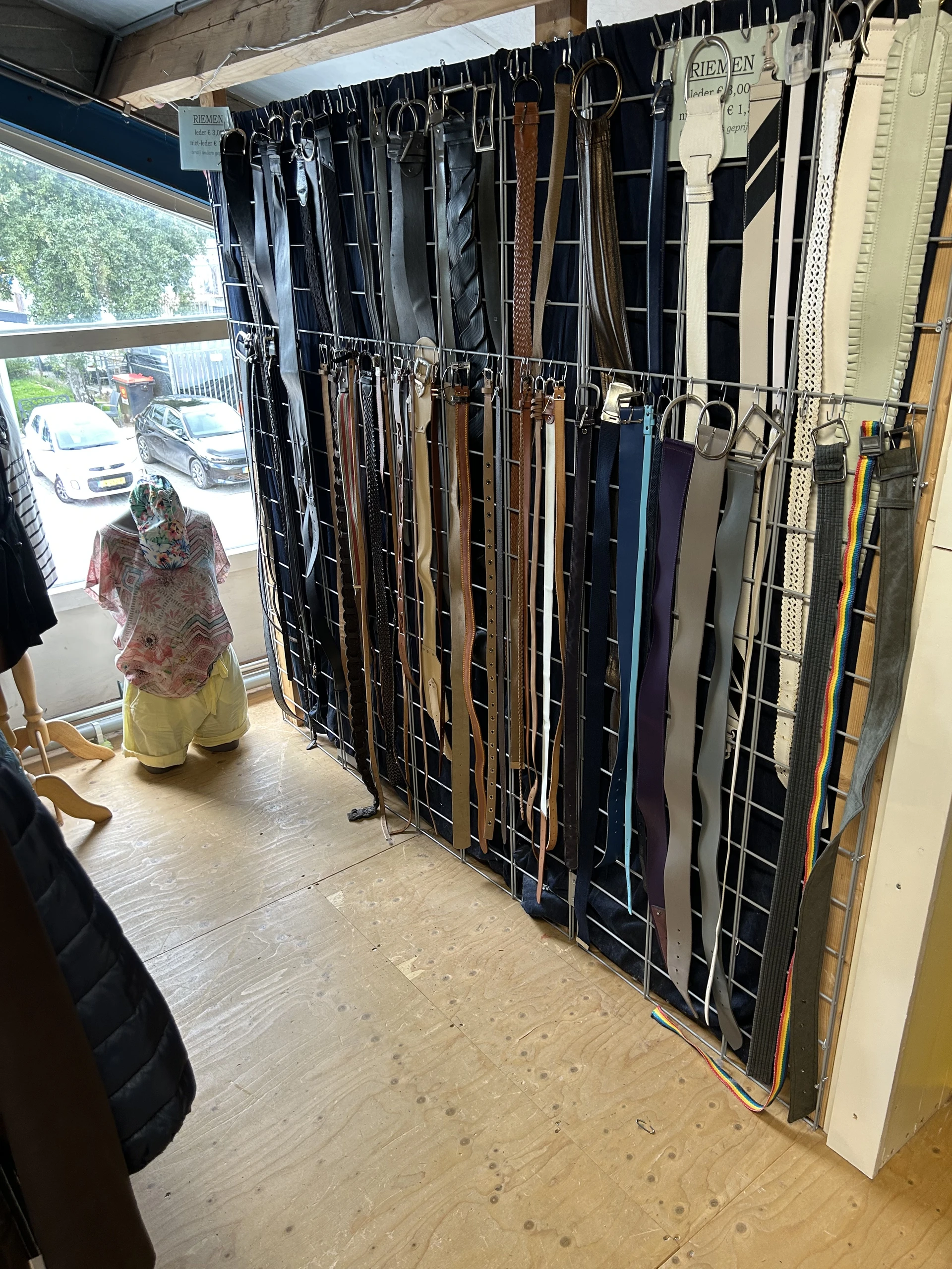 Rekken met opgehangen tweedehands dameskleding in diverse kleuren
