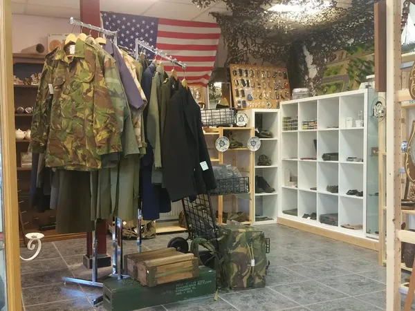 Winkelbinnenruimte met kledingrek, Amerikaanse vlag, witte kasten en diverse tweedehands spullen