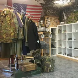Winkelbinnenruimte met kledingrek, Amerikaanse vlag, witte kasten en diverse tweedehands spullen
