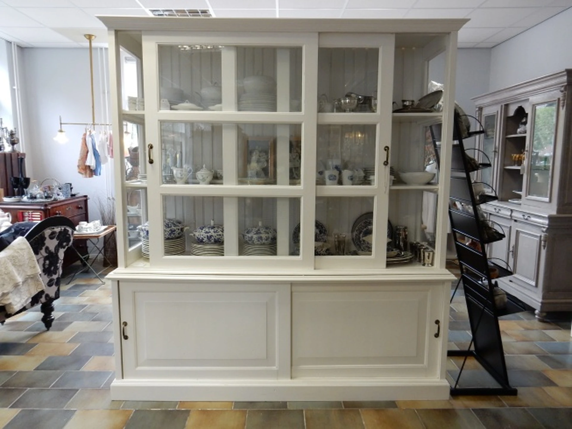 Kringloopwinkel WillysWarenhuis NatuurlijkWonen in Wageningen met tweedehands glaswerk, kleding en lampen