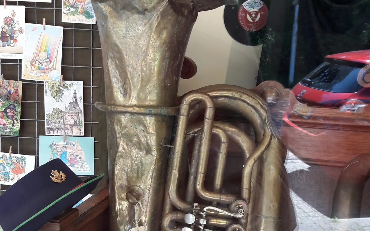 Close-up van een goudkleurig messing blaasInstrument, waarschijnlijk een tuba of trombone, op een tafel