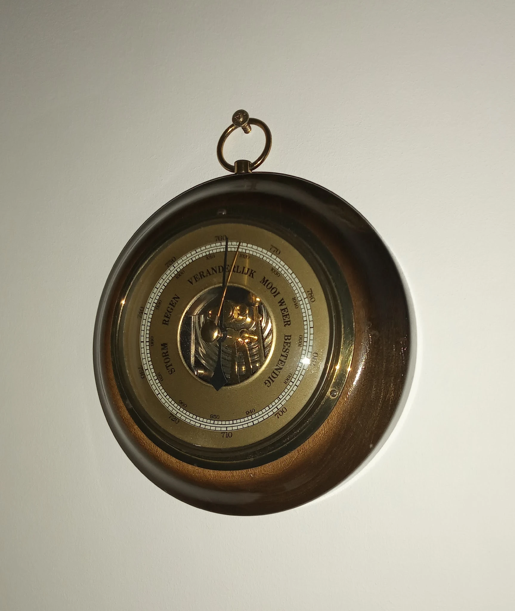 Vintage barometer in ronde bronzen behuizing, hangend aan een oogje, met cirkelvormige schaal en naald