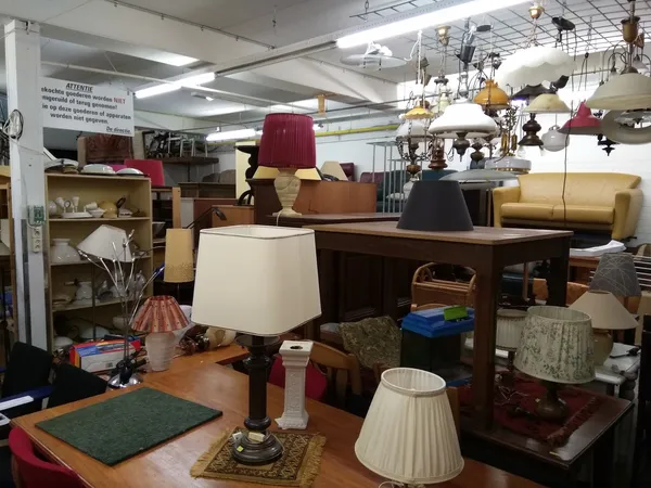 Winkelvloer met uitgestalde meubels, lampen en huishoudelijke spullen in een kringloopwinkel