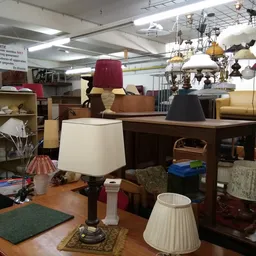 Winkelvloer met uitgestalde meubels, lampen en huishoudelijke spullen in een kringloopwinkel