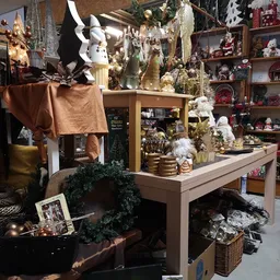 Uitgestalde kerstdecoratie en huishoudelijke artikelen met witte konijnen, gouden accessoires en groene kransen