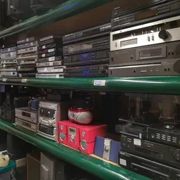 Stellage met vintage audioapparatuur zoals versterkers, cassettespelers en andere elektronische apparaten