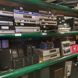 Groene stellingen met stapels elektronische apparatuur en audio-equipement