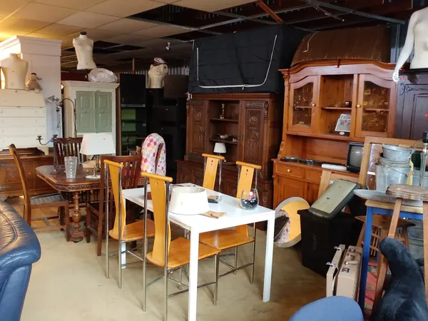 Winkelinterieur met houten meubels, stoelen, kasten en diverse huishoudelijke spullen uitgestald