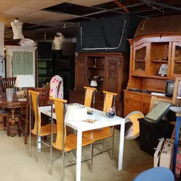 Winkelinterieur met houten meubels, stoelen, kasten en diverse huishoudelijke spullen uitgestald