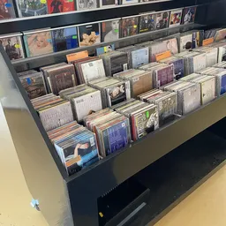 Uitstalling van cd's en dvd's in plastic bakken in een kringloopwinkel