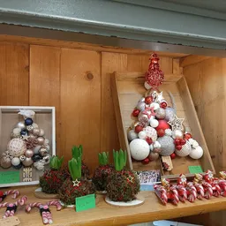 Kerstdecoratie-uitstalling met kerstballen, kerstbomen en versiering op houten planken