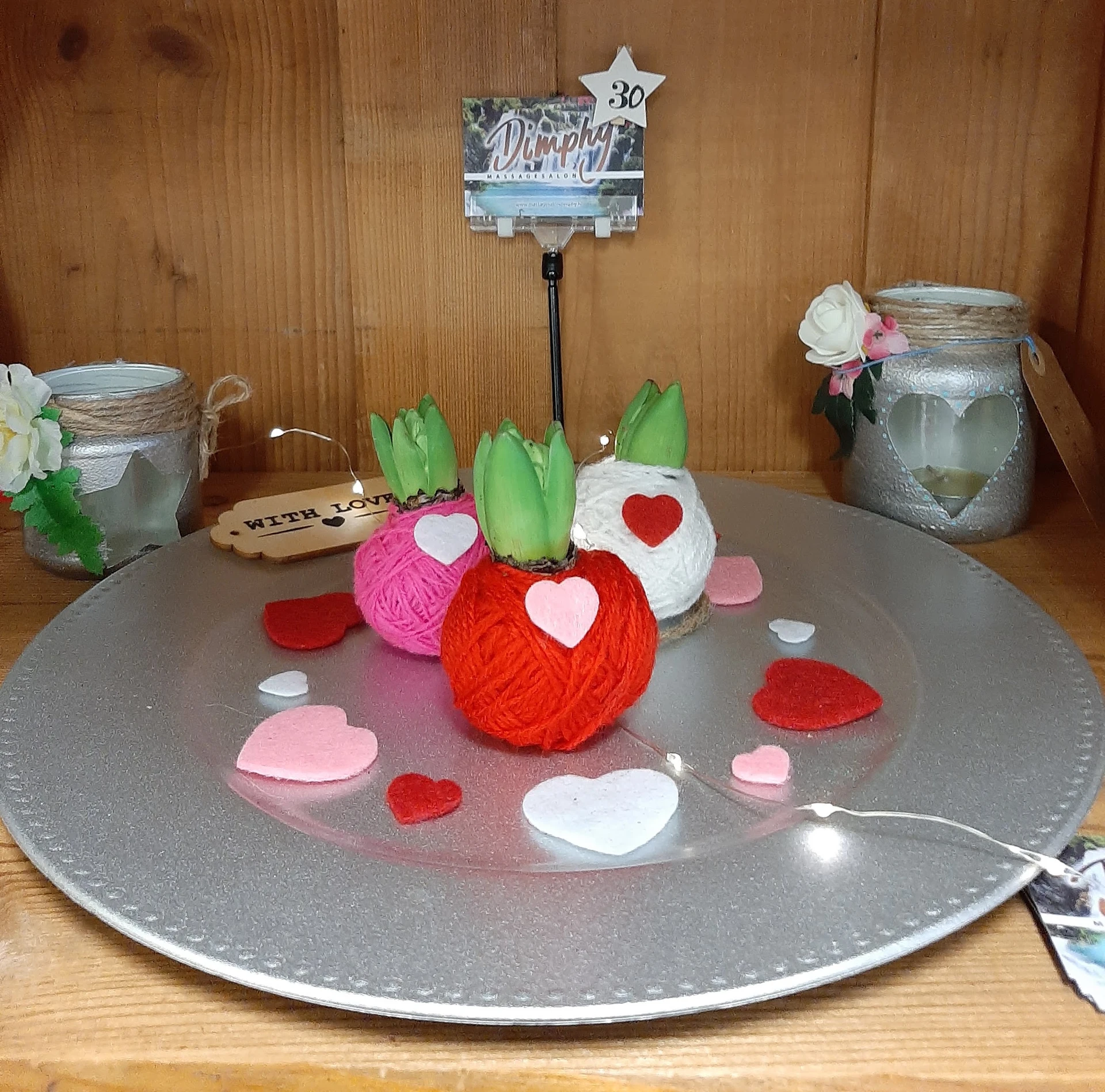 Tafeldecoratie met gekleurde wollen bollen en hartjes rond valentijnsthema