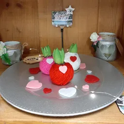 Tafeldecoratie met gekleurde wollen bollen en hartjes rond valentijnsthema
