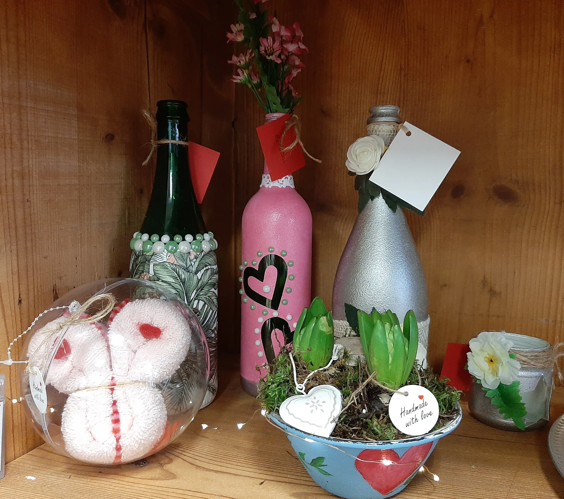 Decoratieve items voor Valentijnsdag: flesjes, kunstbloemen, hartjes en knuffelbeertjes op houten achtergrond