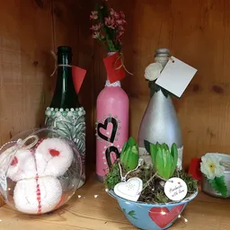 Decoratieve items voor Valentijnsdag: flesjes, kunstbloemen, hartjes en knuffelbeertjes op houten achtergrond