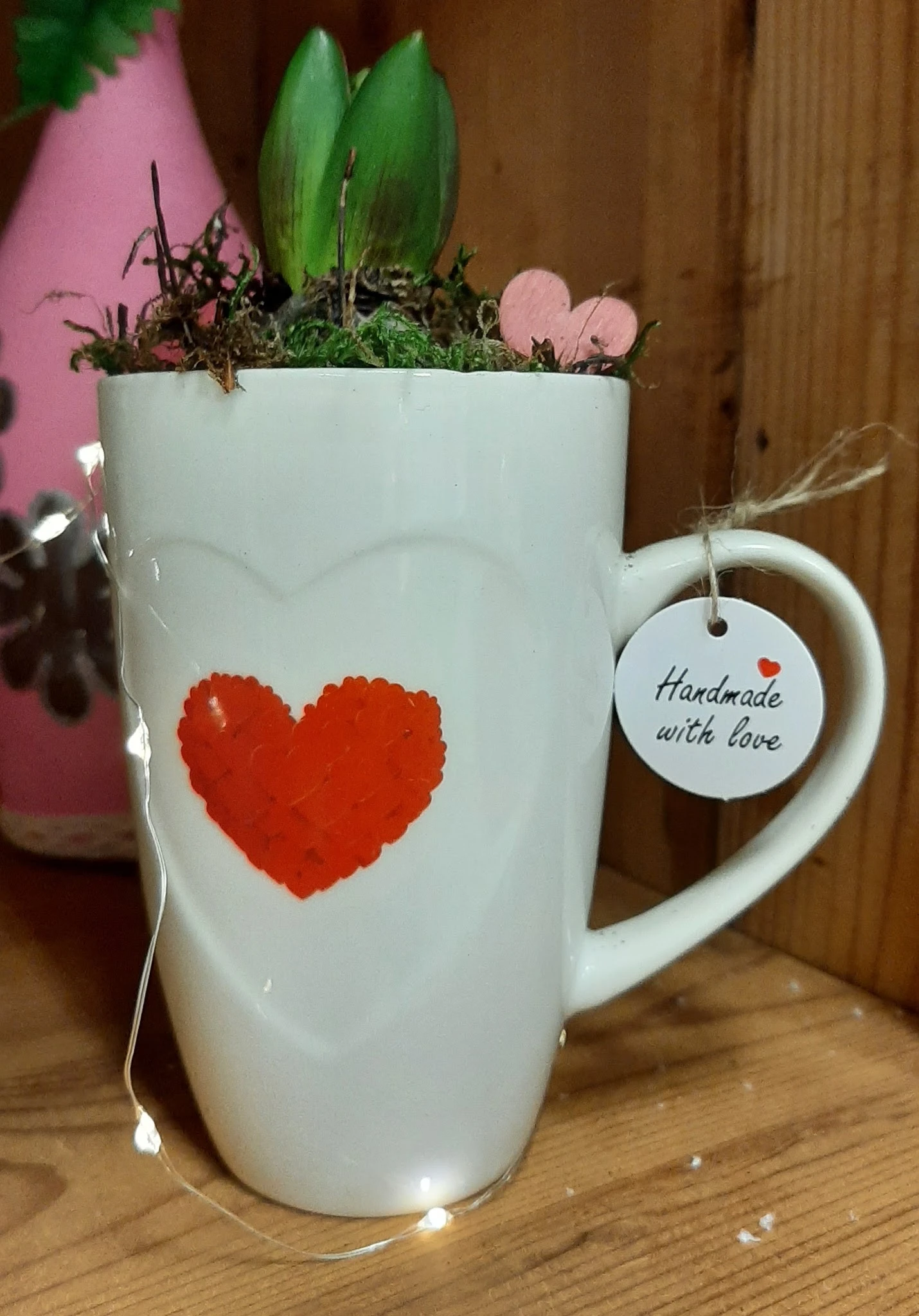 Witte mok met rood hart en label 'Handmade with love' met plantje erin