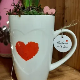 Witte mok met rood hart en label 'Handmade with love' met plantje erin