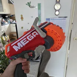 Rood en oranje Nerf-speelgoedpistool met foam kogels wordt in hand gehouden